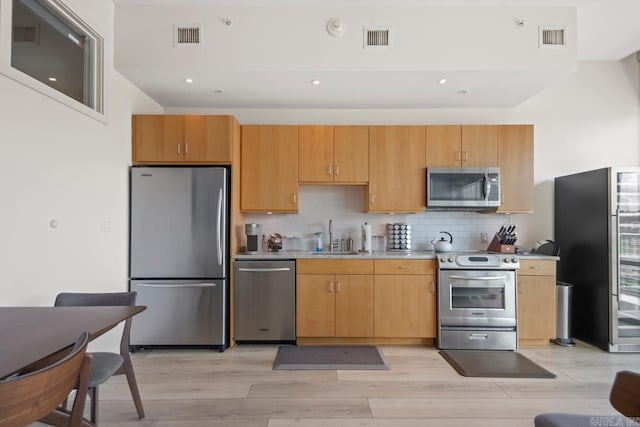 300 E Third St # 509, Little Rock, AR 72201 - kitchen with appliances with stainless steel finishes, light countertops, light wood-type flooring, tasteful backsplash, and recessed lighting