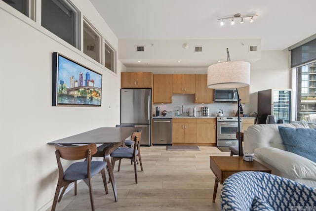 300 E Third St # 509, Little Rock, AR 72201 - kitchen with stainless steel appliances, light wood-style floors, tasteful backsplash, and light countertops