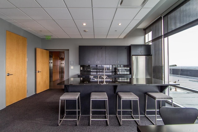300 E Third St # 509, Little Rock, AR 72201 - kitchen with appliances with stainless steel finishes, a kitchen bar, dark countertops, a paneled ceiling, and recessed lighting