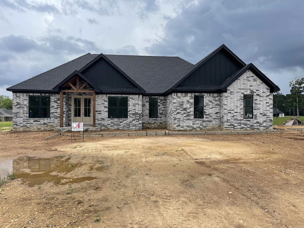 265 Grant 844 Rd, Sheridan, AR 72150 - view of front facade with board and batten siding, brick siding, and a shingled roof