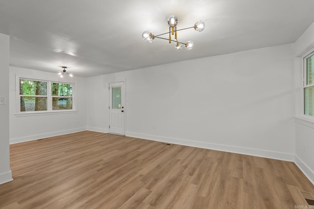 25501 Kanis Rd, Little Rock, AR 72223 - unfurnished room with a chandelier and light wood-style flooring