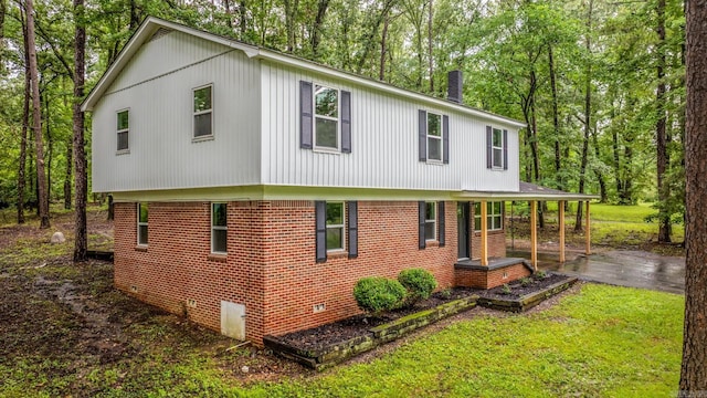 25501 Kanis Rd, Little Rock, AR 72223 - view of side of property featuring a porch, a yard, view of wooded area, and brick siding