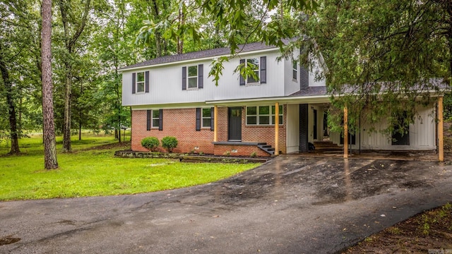 25501 Kanis Rd, Little Rock, AR 72223 - view of front facade with brick siding, asphalt driveway, a front lawn, a shingled roof, and a carport