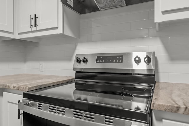 25501 Kanis Rd, Little Rock, AR 72223 - kitchen view of stainless steel electric range, backsplash, white cabinetry, and extractor fan