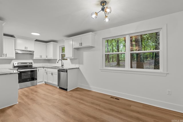 25501 Kanis Rd, Little Rock, AR 72223 - kitchen with stainless steel appliances, under cabinet range hood, white cabinetry, and light wood-type flooring