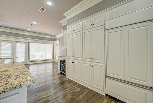 kitchen featuring beverage cooler, crown molding, dark wood-type flooring, recessed lighting, and light stone countertops