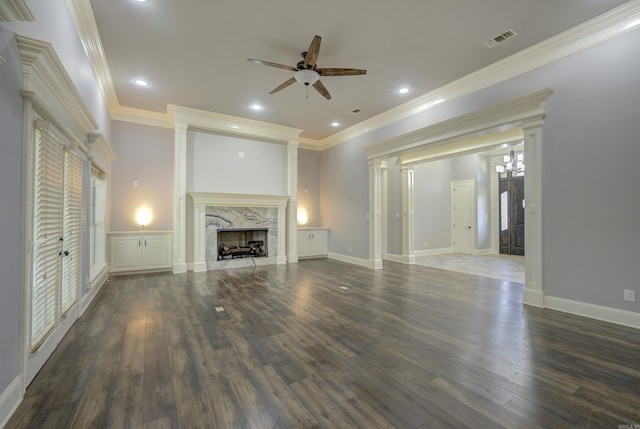 unfurnished living room featuring a ceiling fan, wood finished floors, a high end fireplace, ornamental molding, and recessed lighting