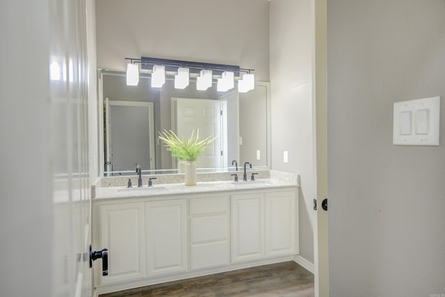 full bathroom with double vanity and wood finished floors