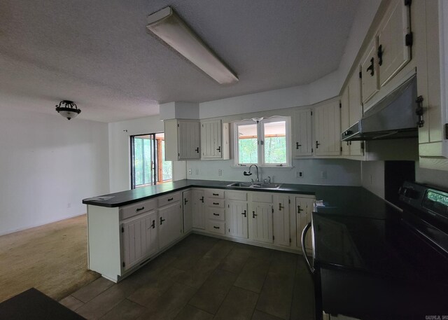 1 Sierra Ln, Hot Springs Village, AR 71909 - kitchen with black electric range, under cabinet range hood, a peninsula, dark countertops, and a textured ceiling