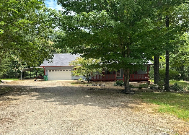 57 Cherokee Acres Dr, Cherokee Village, AR 72529 - obstructed view of property with a carport, dirt driveway, a garage, and a porch