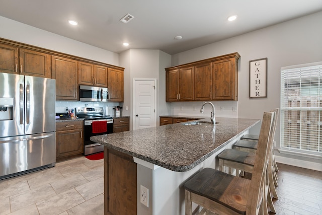 526 NW 62nd Ave, Bentonville, AR 72713 - kitchen featuring stainless steel appliances, decorative backsplash, a kitchen breakfast bar, a peninsula, and recessed lighting