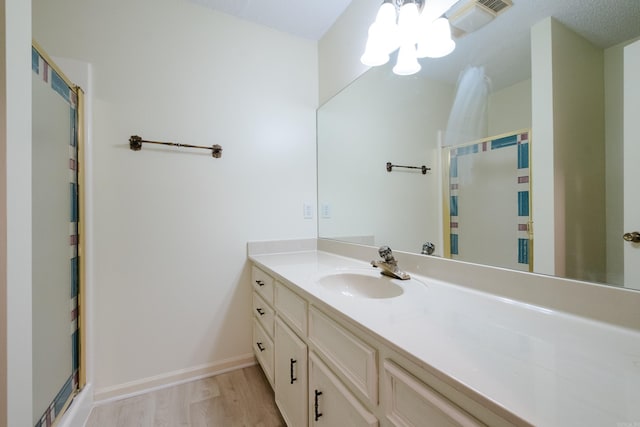 520 Cambridge Place Dr, Little Rock, AR 72227 - bathroom featuring a chandelier, vanity, wood finished floors, and a shower with door