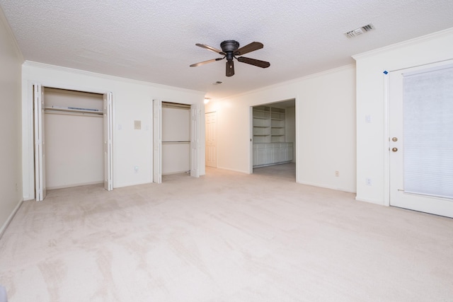 520 Cambridge Place Dr, Little Rock, AR 72227 - unfurnished bedroom with ornamental molding, two closets, a textured ceiling, light colored carpet, and a ceiling fan