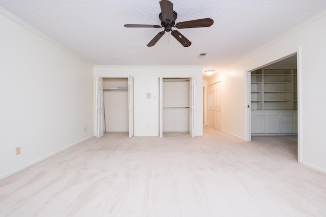 520 Cambridge Place Dr, Little Rock, AR 72227 - unfurnished bedroom with a textured ceiling, ornamental molding, light carpet, multiple closets, and a ceiling fan