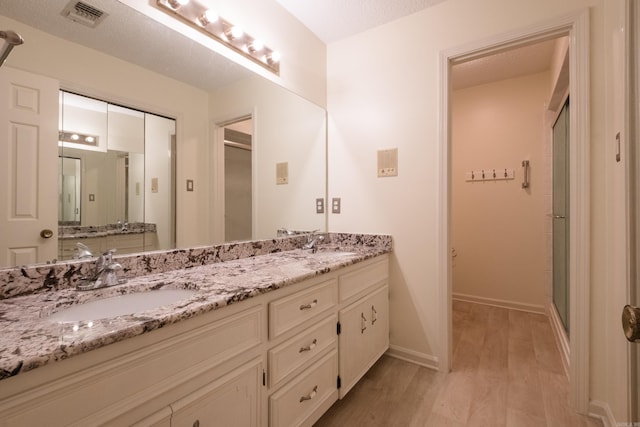 520 Cambridge Place Dr, Little Rock, AR 72227 - bathroom with wood finished floors, double vanity, and a stall shower