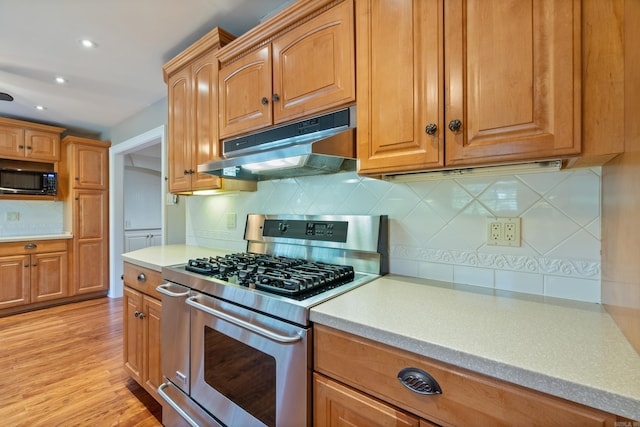 300 Beaconsfield Rd, Sherwood, AR 72120 - kitchen with stainless steel gas range oven, under cabinet range hood, black microwave, decorative backsplash, and light countertops