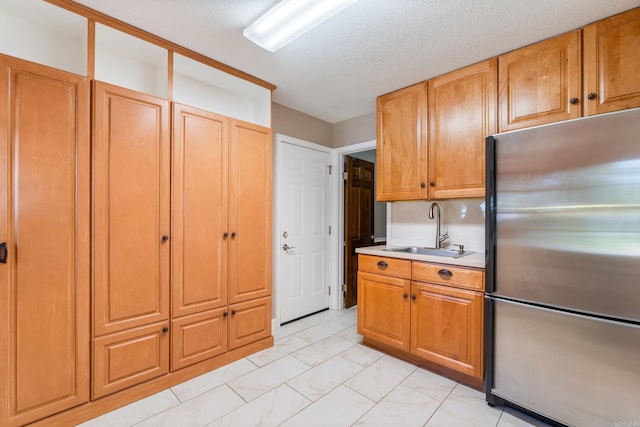 300 Beaconsfield Rd, Sherwood, AR 72120 - kitchen with freestanding refrigerator, light marble finish flooring, light countertops, decorative backsplash, and a textured ceiling