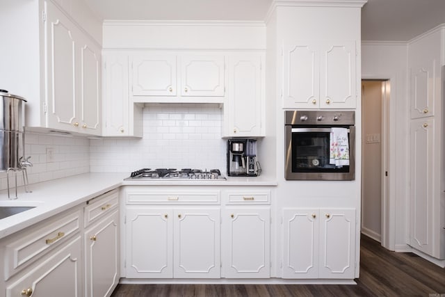 20 Robinwood Rd, Little Rock, AR 72227 - kitchen with appliances with stainless steel finishes, white cabinets, dark wood-type flooring, light countertops, and decorative backsplash