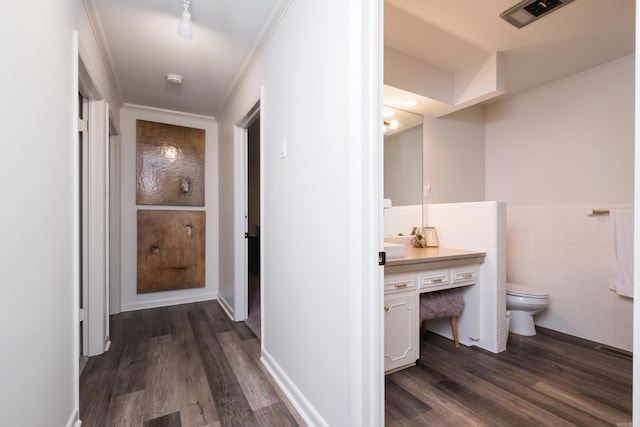 20 Robinwood Rd, Little Rock, AR 72227 - hallway featuring dark wood-style flooring, tile walls, crown molding, and a wainscoted wall