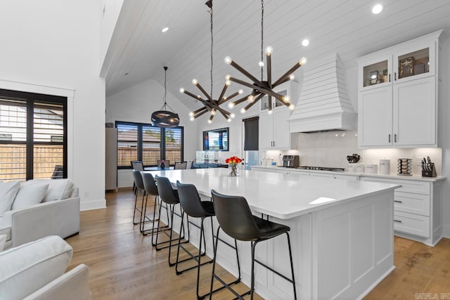 7509 S Shoreline, Benton, AR 72019 - kitchen featuring open floor plan, a chandelier, light countertops, light wood-style flooring, and custom exhaust hood