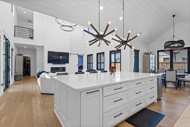 7509 S Shoreline, Benton, AR 72019 - kitchen with a chandelier, high vaulted ceiling, white cabinets, light wood-style floors, and light countertops