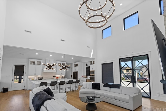 7509 S Shoreline, Benton, AR 72019 - living area with a chandelier, a towering ceiling, light wood-style flooring, and recessed lighting