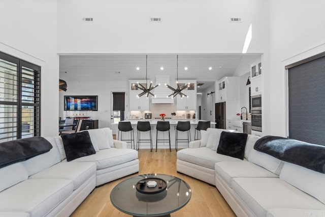 7509 S Shoreline, Benton, AR 72019 - living area with a chandelier, light wood-style flooring, and a towering ceiling