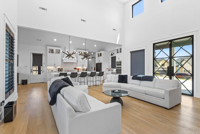 7509 S Shoreline, Benton, AR 72019 - living area with a towering ceiling, light wood-style flooring, a chandelier, and recessed lighting