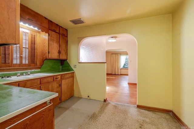 5302 A St, Little Rock, AR 72205 - kitchen featuring arched walkways, brown cabinetry, and light countertops