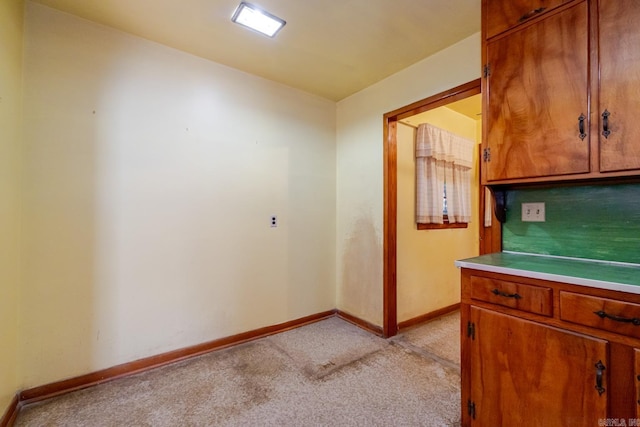 5302 A St, Little Rock, AR 72205 - kitchen featuring light colored carpet, brown cabinetry, and light countertops