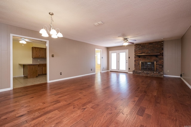 304 Dogwood Dr, Benton, AR 72019 - unfurnished living room with a ceiling fan, wood finished floors, a fireplace, a textured ceiling, and a chandelier