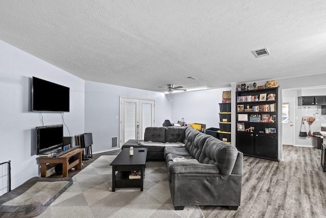1324 Sunset Dr, Conway, AR 72034 - living room with a textured ceiling, a ceiling fan, wood finished floors, and french doors