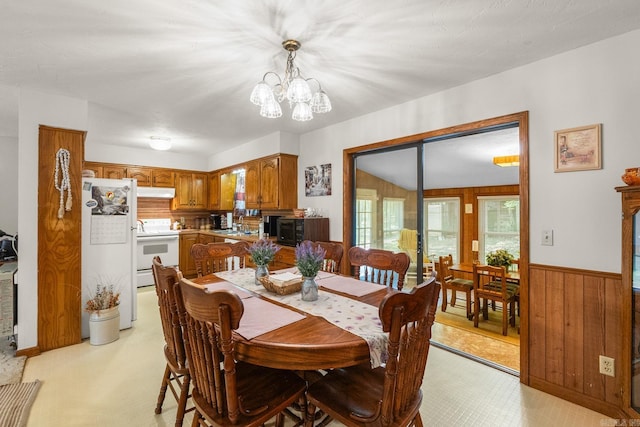 424 Center Rdg, Drasco, AR 72543 - dining space with wood walls, a chandelier, and a wainscoted wall