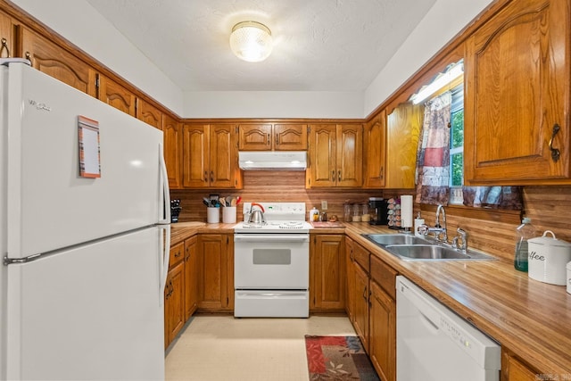 424 Center Rdg, Drasco, AR 72543 - kitchen with white appliances, under cabinet range hood, brown cabinetry, and light countertops