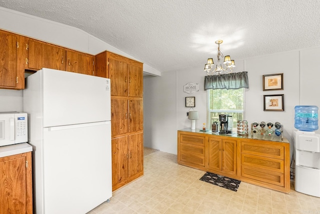 424 Center Rdg, Drasco, AR 72543 - kitchen with white appliances, a chandelier, a textured ceiling, brown cabinets, and light flooring