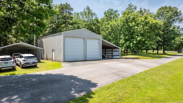 424 Center Rdg, Drasco, AR 72543 - garage featuring a detached carport, a garage, driveway, and view of wooded area