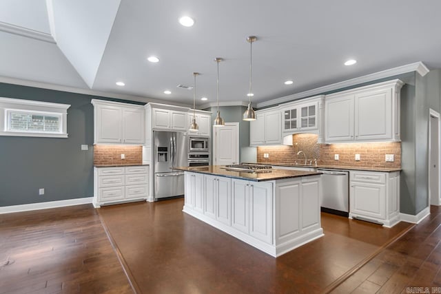 9 Bishop Pl, Little Rock, AR 72223 - kitchen with appliances with stainless steel finishes, crown molding, white cabinets, decorative backsplash, and a kitchen island