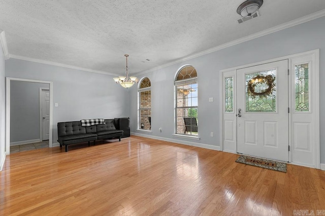 31 Auburn Hills Dr, Greenbrier, AR 72058 - foyer entrance featuring a chandelier, a textured ceiling, light wood-style flooring, and ornamental molding
