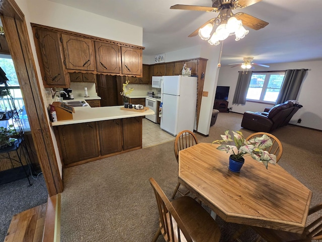 1206 Broadway Ave, Bull Shoals, AR 72619 - kitchen with white appliances, a ceiling fan, a peninsula, and light carpet