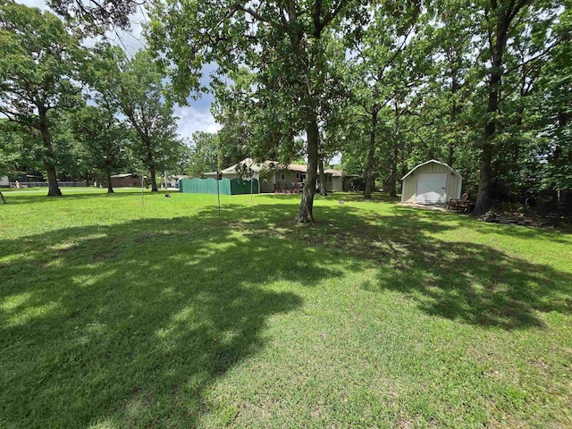 1206 Broadway Ave, Bull Shoals, AR 72619 - view of grassy yard featuring a storage unit and a detached garage
