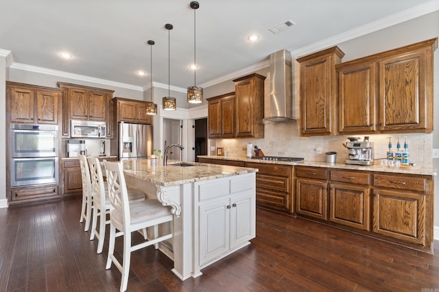 2705 Pulaski Dr, Conway, AR 72034 - kitchen featuring appliances with stainless steel finishes, wall chimney range hood, brown cabinets, dark wood finished floors, and recessed lighting