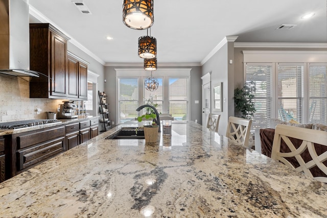2705 Pulaski Dr, Conway, AR 72034 - kitchen with wall chimney exhaust hood, stainless steel gas cooktop, light stone counters, crown molding, and recessed lighting