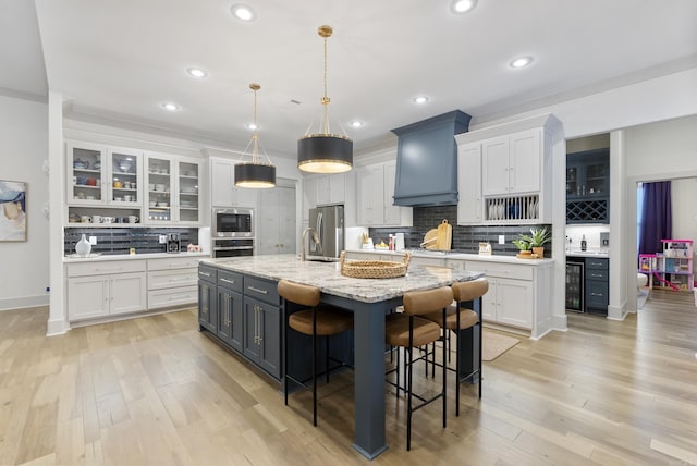 2960 Orchard View Dr, Conway, AR 72034 - kitchen featuring stainless steel appliances, premium range hood, wine cooler, white cabinets, and recessed lighting