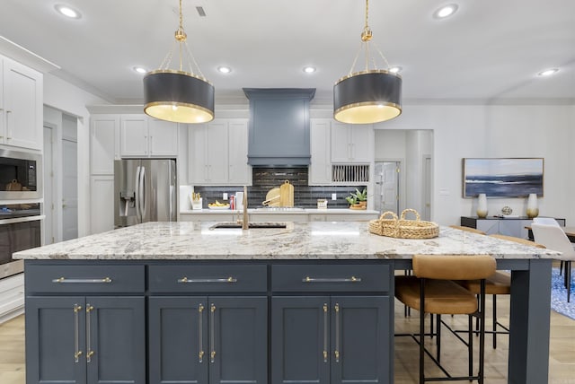 2960 Orchard View Dr, Conway, AR 72034 - kitchen featuring stainless steel appliances, premium range hood, white cabinetry, a large island with sink, and decorative backsplash