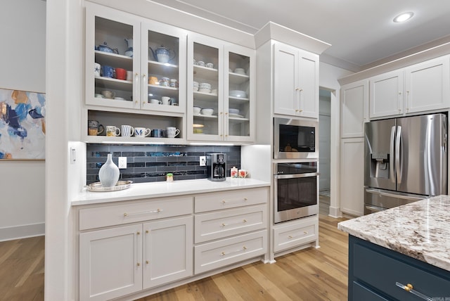 2960 Orchard View Dr, Conway, AR 72034 - kitchen featuring appliances with stainless steel finishes, decorative backsplash, white cabinetry, light wood finished floors, and recessed lighting