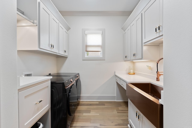 2960 Orchard View Dr, Conway, AR 72034 - washroom with washer and dryer, cabinet space, and light wood-type flooring