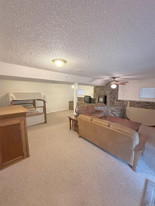 900 Davidson Cir, Edgemont, AR 72044 - living area with a textured ceiling, carpet floors, ceiling fan, and a stone fireplace