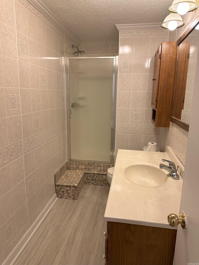 900 Davidson Cir, Edgemont, AR 72044 - full bathroom with ornamental molding, vanity, tile walls, a stall shower, and wood finished floors
