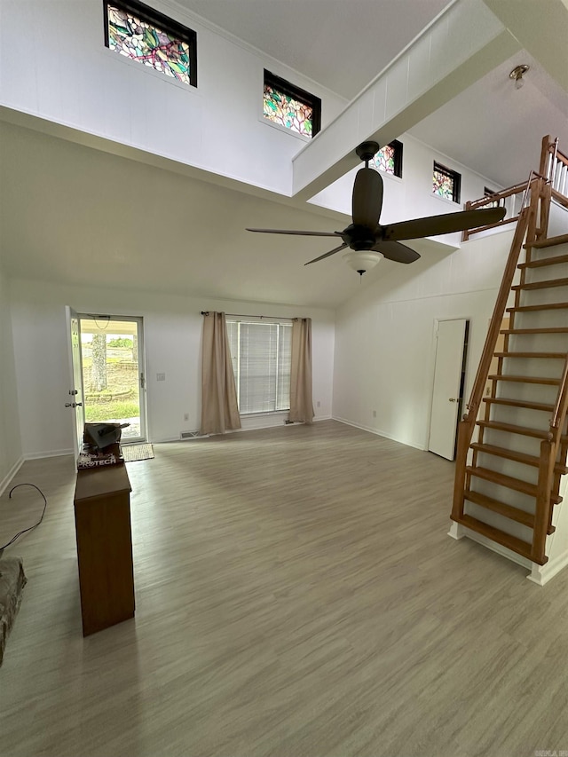 900 Davidson Cir, Edgemont, AR 72044 - unfurnished living room with stairway, ceiling fan, a high ceiling, and light wood-style flooring