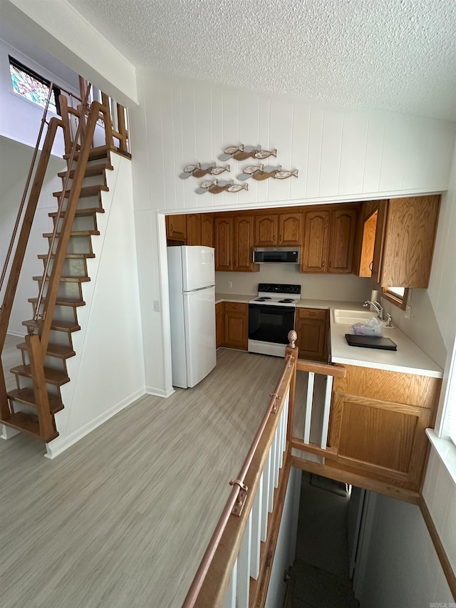 900 Davidson Cir, Edgemont, AR 72044 - kitchen with white appliances, a textured ceiling, ventilation hood, light countertops, and light wood-type flooring